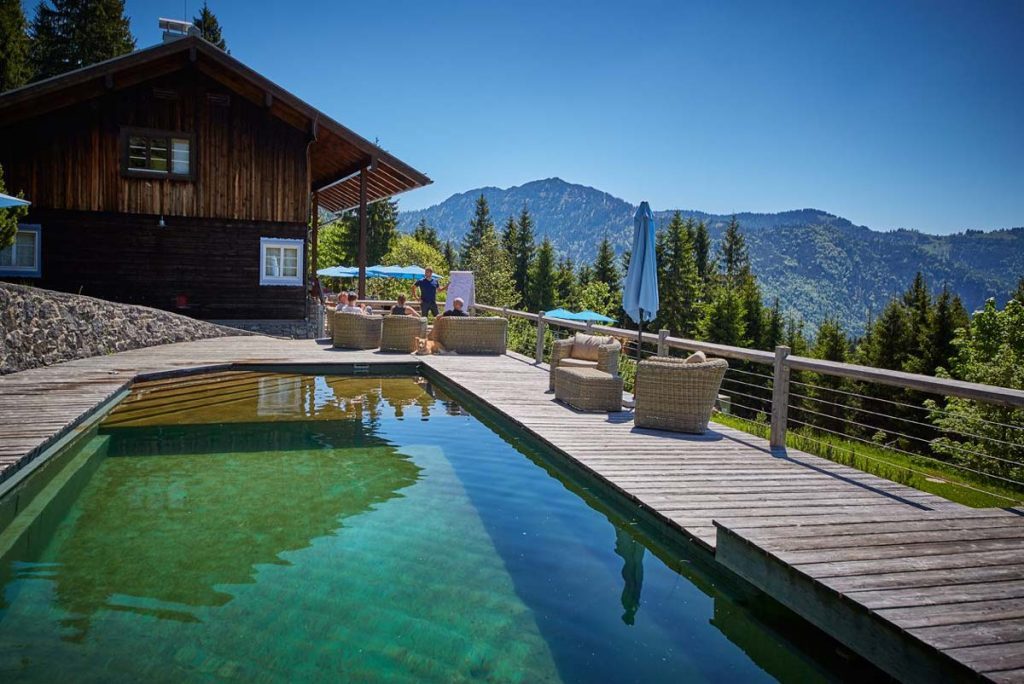Naturpool mit Liegestühlen und Loungeecke auf der Terrasse