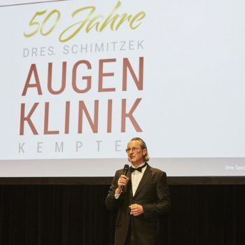 Dr. Thilo Schimitzek begrüßt die Gäste der Augenklinik Kempten auf der Bühne im Kornhaus Kempten.