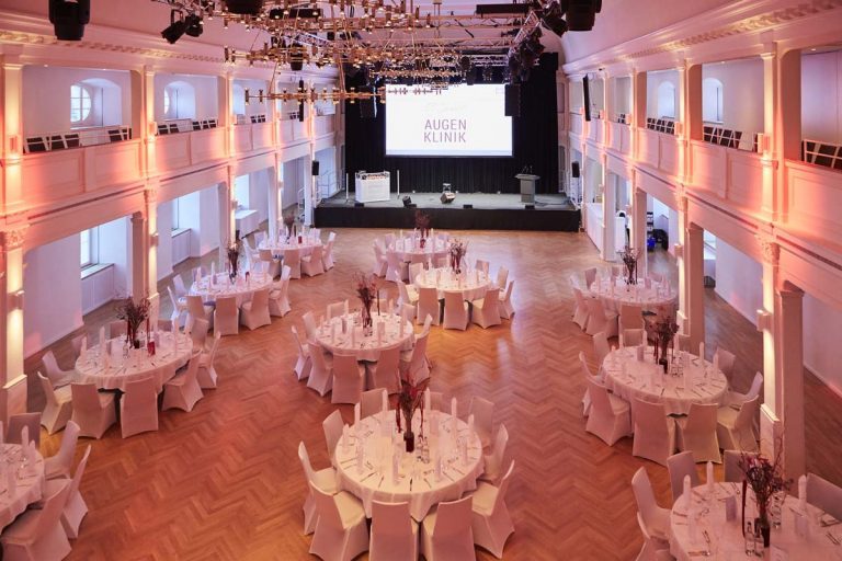 Dekorierter Festsaal im Kornhaus Kempten mit Bühne vor Beginn der Jubiläumsfeier.