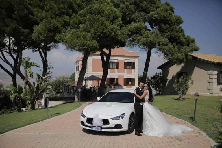 Villa Giuliana Sizilien - Brautpaar mit Hochzeitsauto Maserati unter Pinienbäumen