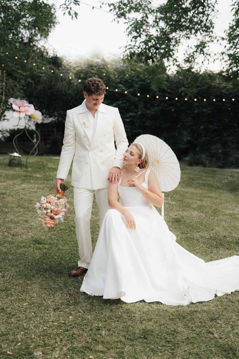 Braut und Bräutigam mit Brautstrauß und Sonnenschirm - geplant von Julia Truisi weddings & parties