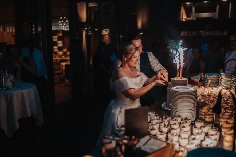 Anschnitt Hochzeitstorte mit Feuerwerk - Braut und Bräutigam - wer hat die Hand oben