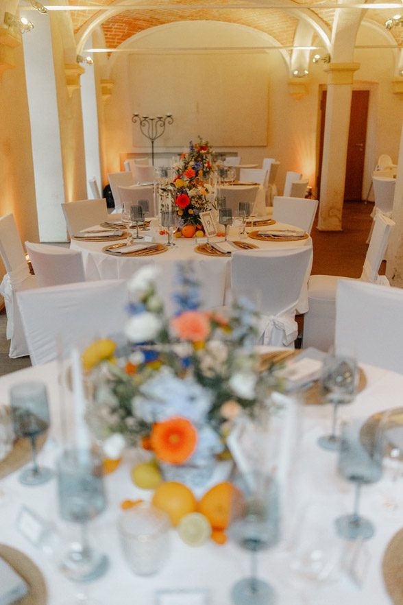 Hochzeit - Dekorierter Kreuzgewölbesaal im Weingut mit Akzenten in Blau und Orange