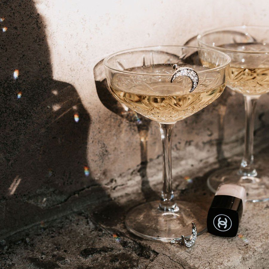 Eventplanung Heidelberg: zwei gefüllte Champagnerschalen auf steinerner Brüstung, im Sonnenlicht tanzen Lichtreflexe
