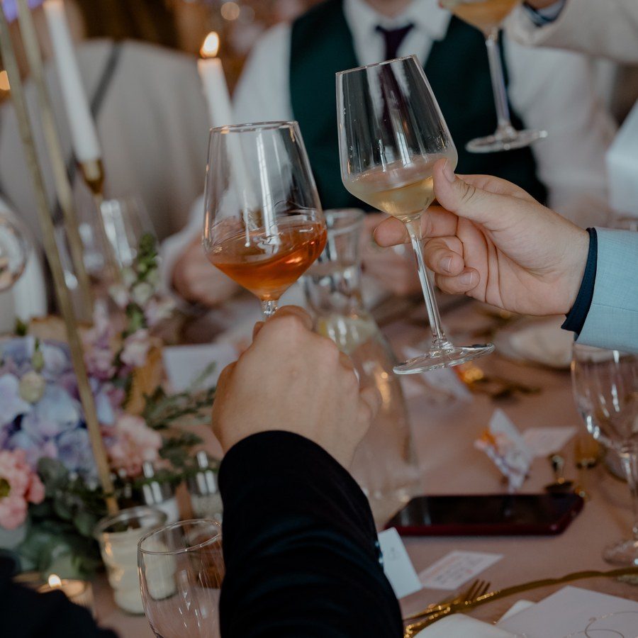Eventplanung Heilbronn: Gäste stoßen mit Weingläsern über der festlich gedeckten Tafel an