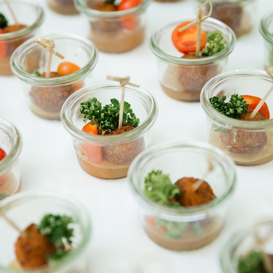 Eventplanung Tegernsee: Fingerfood in kleinen Gläsern auf der weißen Empfangstafel