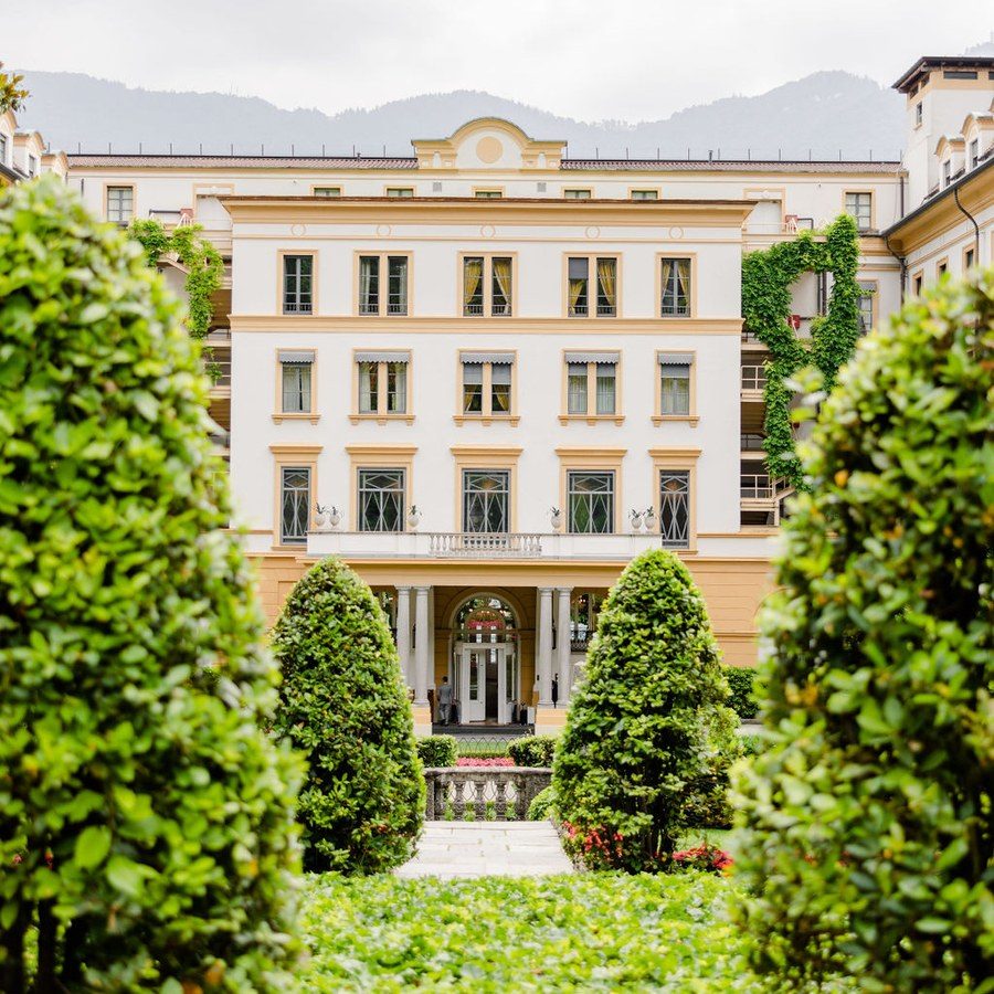Freie Trauung Frankfurt: Blick durch einen Garten mit Formschnitthecken auf die helle Fassade einer Villa