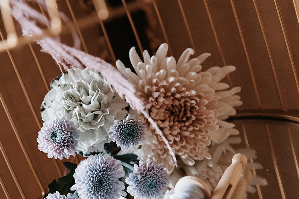 Detailaufnahme eines goldenen Deko-Reifs mit Dahlien, Chrysanthemen und Pampasgras bei einer Hochzeit in Stuttgart