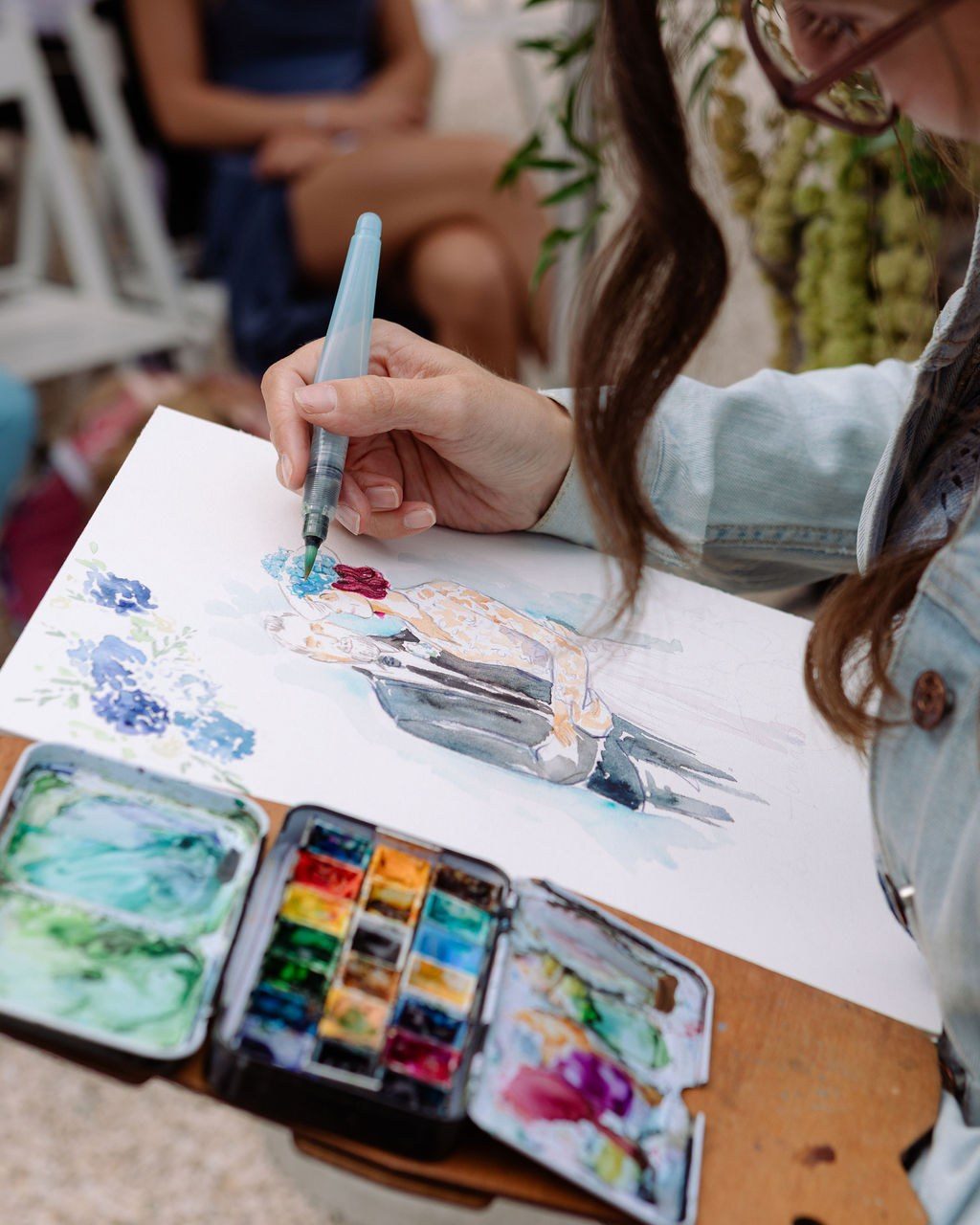 Hochzeitsplanerin Frankfurt: Malerin hält Gäste live in Aquarell fest, daneben ihr Farbkasten