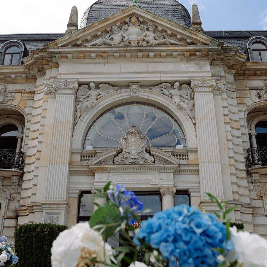 Hochzeitsplanung Bonn: historisches Palais mit blauem Hortensienschmuck als Hochzeitslocation