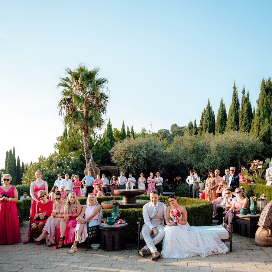 Hochzeitsplanung Gardasee: Trauung im Garten zwischen Palmen und Zypressen, die Gäste sitzen im Halbrund