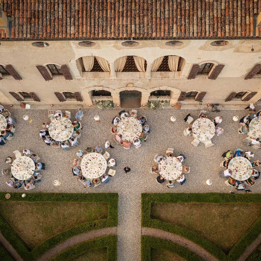 Hochzeitsplanung Neckar: Luftbild eines Innenhofs mit runden, festlich gedeckten Tischen vor einem historischen Gebäude