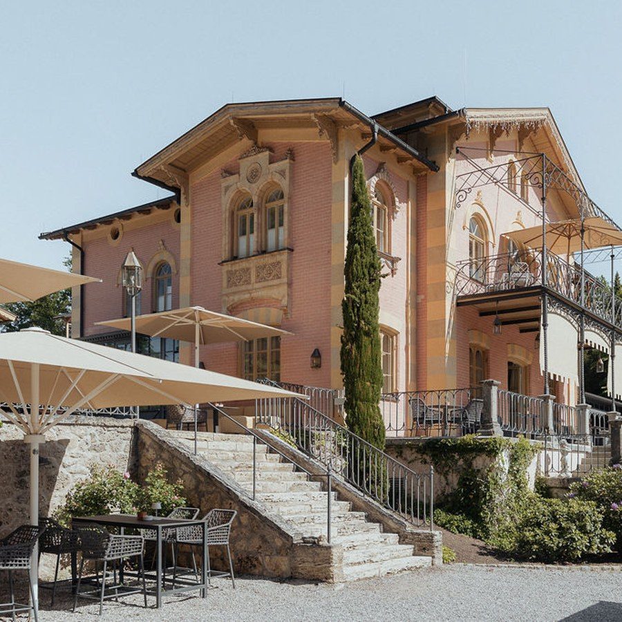 Hochzeitsplanung Starnberg: historische Villa mit Freitreppe, Terrasse und Sonnenschirmen am Starnberger See