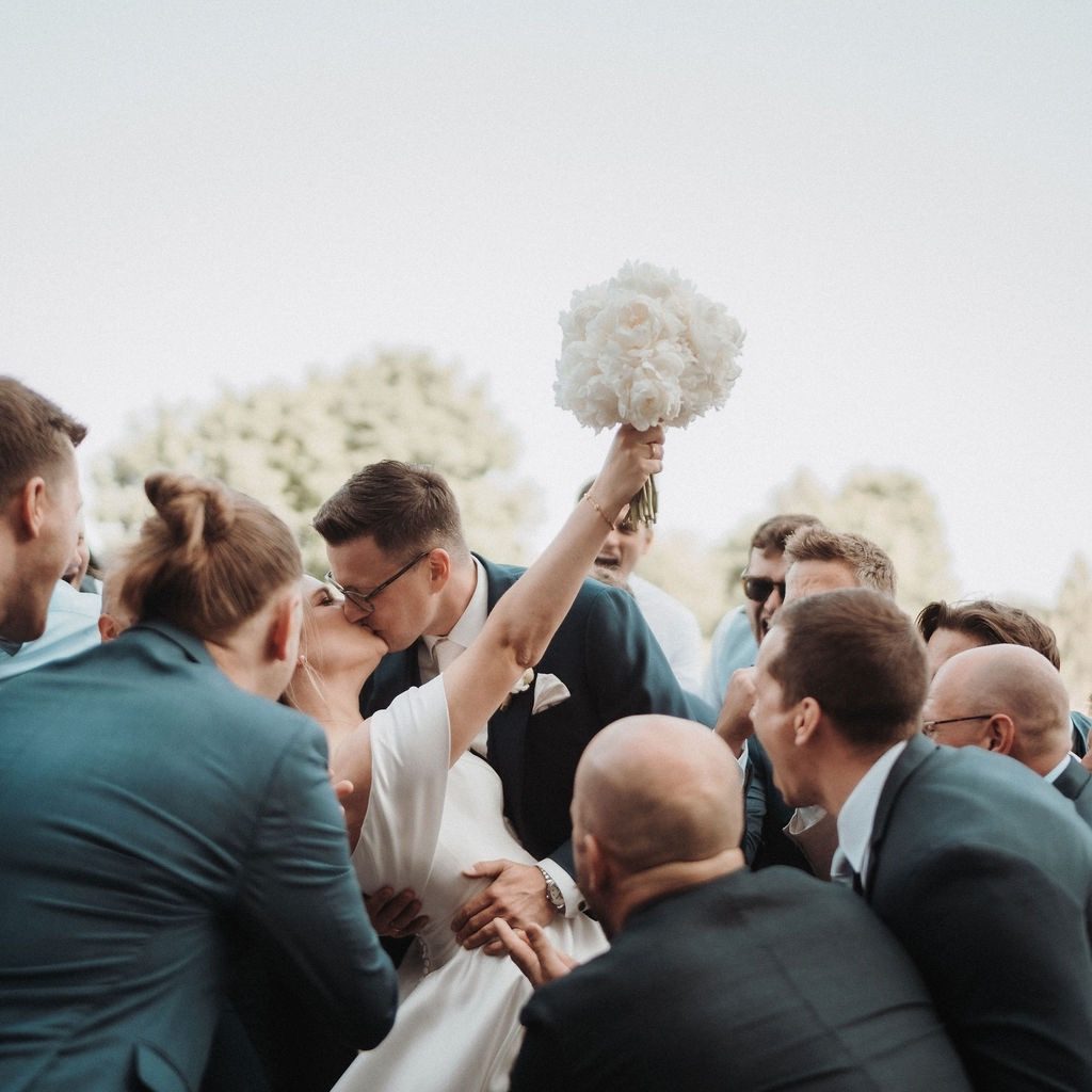 Hochzeitsplanung Ulm – Brautpaar küsst sich umringt von jubelnden Gästen, geplant von Julia Truisi
