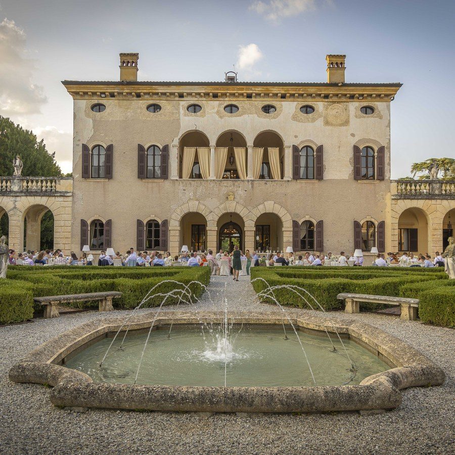 Hochzeitsplanung Verona: historische Villa mit Springbrunnen und Buchsgarten, davor die Hochzeitsgesellschaft