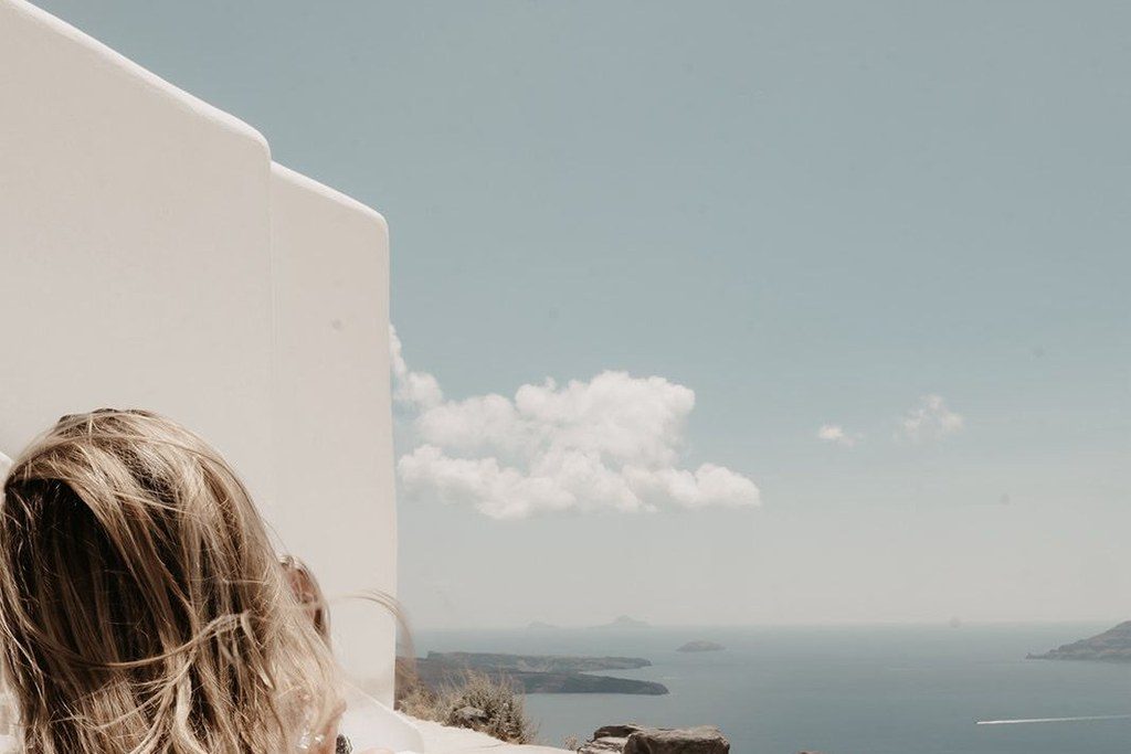 Gast sitzt am Rand des Infinity-Pools und blickt über das Meer bis zu den Nachbarinseln